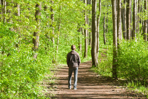 Person walking outdoors in a park on a sunny morning